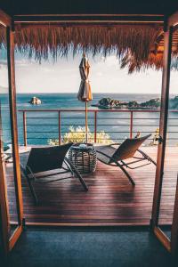 a deck with two chairs and a umbrella and the ocean at Langkhai Garden in Koh Tao