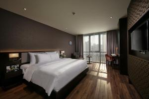 a bedroom with a large bed and a flat screen tv at Grandiose Hotel & Spa in Hanoi