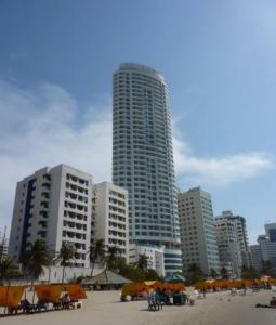 uma praia com guarda-sóis em frente a edifícios altos em Beach front Apartament em Cartagena das Índias