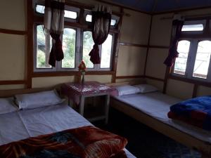 Vamoose Arjastik Homestay في Pedong: غرفة بسريرين ونوافذ