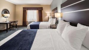 a hotel room with two beds and a desk at Best Western Plus Northwest Inn and Suites Houston in Houston