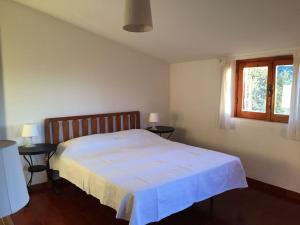 um quarto com uma cama branca com duas mesas e uma janela em Argentella House em Palombara Sabina