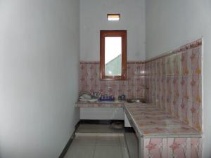 ein Bad mit einem Waschbecken und einem Spiegel in der Unterkunft Agung Safira Homestay in Bromo