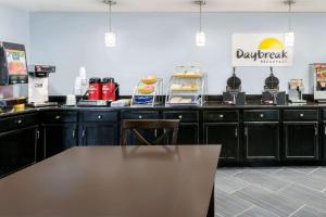 a restaurant counter with a table in front of it at Days Inn by Wyndham Greensboro Airport in Greensboro