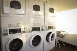 four washers and dryers in a laundry room at Emerald Park Motel in Emerald