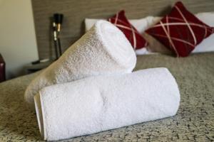 una pila di asciugamani bianchi seduti su un letto di Emerald Park Motel a Emerald