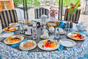 a table with plates of food on top at Lanka Golf Villa Collection - Villa Rachel's Sun in Kandy