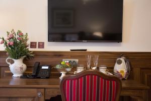 a desk with a television and a chair and a phone at Heritage Hotel Cardo in Split