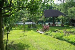 a park with a gazebo and chairs in the grass at Una holiday house in Bihać