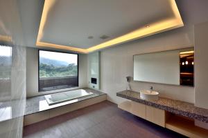 a bathroom with a tub and a sink and a window at liHotel in Xizhi