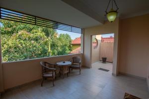 um quarto com uma mesa e cadeiras e uma grande janela em Ada Waktu Homestay em Yogyakarta