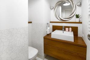 a bathroom with a sink and a mirror at Nadwiślańska Apartment in Warsaw +4 photos
