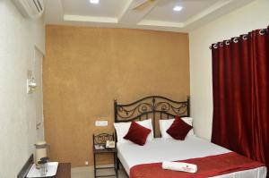 a bedroom with a bed with a red curtain at Hotel Preetam Aurangabad in Aurangabad
