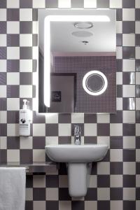a bathroom with a sink and a mirror at Pangea Pod Hotel in Whistler