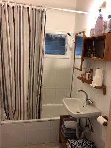 ein Bad mit einem Duschvorhang und einem Waschbecken in der Unterkunft Home Tel Aviv by sourasky medical center ichilov in Tel Aviv