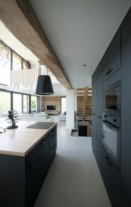 a kitchen with black cabinets and a kitchen island at Venez Chez Vous - Chalet Le Villaret - Vue lac in Saint-Jorioz