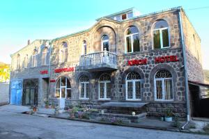 戈里斯Kirch Hotel & Restaurant的一座挂着招牌的古老石头建筑