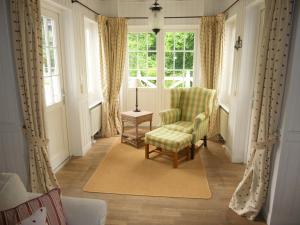 ein Wohnzimmer mit einem Stuhl und einem Fenster in der Unterkunft Das Gut klein Bollhagen in Wittenbeck