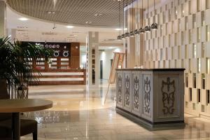 a lobby with a table and a counter in a store at Vega Hotel in Tolyatti