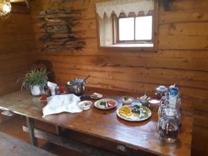 una mesa en una cabaña de madera con comida. en Toomarahva Farmstay, en Altja