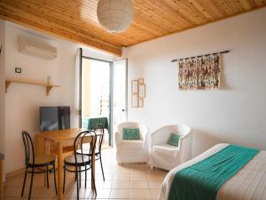 een slaapkamer met een bed en een tafel en stoelen bij Domus De Janas Sul Mare in Bari Sardo