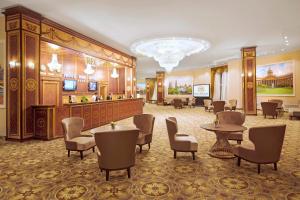 um átrio do hotel com mesas e cadeiras e um bar em Prince Park Hotel em Moscovo
