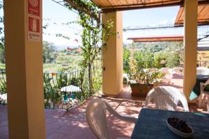 Zimmer mit einem Tisch und Stühlen auf einer Terrasse in der Unterkunft Domus De Janas Sul Mare in Bari Sardo