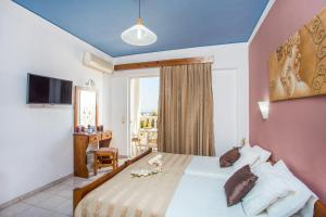 um quarto de hotel com uma cama e uma janela em Iatridis Studios Faliraki em Faliraki