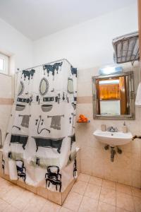 a bathroom with a black and white shower curtain and a sink at Iatridis Studios Faliraki in Faliraki