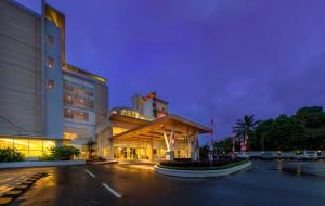 een gebouw met een parkeerplaats ervoor bij Horison Ultima Timika in Timika