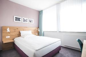 Postel nebo postele na pokoji v ubytování Ulmer Münster Hotel
