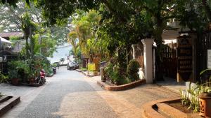 una strada con alberi e piante sul lato di un edificio di Hoxieng Guesthouse 1 a Luang Prabang