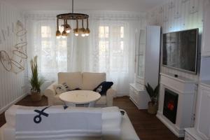 a living room with a couch and a tv at Dompanorama- Luxuriöse FeWo in Havelberg