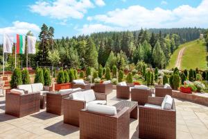 - un ensemble de chaises et de tables sur une terrasse dans l'établissement Hotel Yastrebets Wellness & Spa, à Borovets