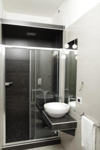 a bathroom with a sink and a glass shower at Maison Maneli in Rome