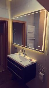 een badkamer met een wastafel en een grote spiegel bij uebernachtung unna in Unna