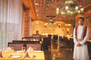 a man standing in front of a dining room at Asdal Gulf Inn Boutique Hotel- SEEF in Manama