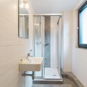 a bathroom with a glass shower and a sink at Hotel Seeadler in Friedrichshafen