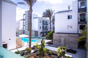 widok z lotu ptaka na budynek z basenem i palmami w obiekcie Futura Apartment w Corralejo