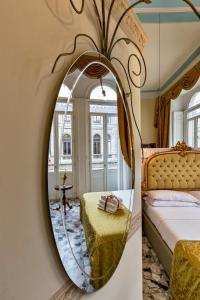 a mirror in a bedroom with a bed and a table at B&B Art Suite Santa Brigida in Naples