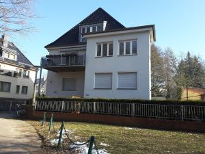 une maison blanche avec une clôture devant elle dans l'établissement schöne Ferienwohnung am Rande der Altstadt, à Wittemberg