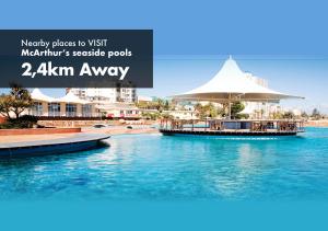 a resort with a swimming pool and a boat in the water at Faith, Hope & Love Self Catering in Port Elizabeth