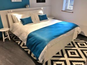 a bedroom with a large bed with blue pillows at The Little Houses - Malmedy - in Malmedy