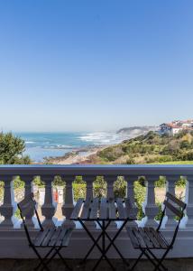 a picnic table on a balcony overlooking the ocean at Villa Anvers Guethary in Bidart