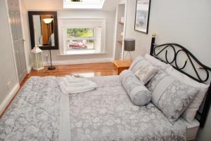 een slaapkamer met een groot bed met kussens en een raam bij Tranquility in Longford