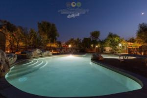 a swimming pool at night with the lights on at Torre Sabea in Gallipoli