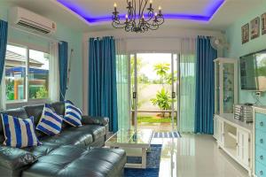 - un salon avec un canapé en cuir et des rideaux bleus dans l'établissement Aonang Sweet Blue Sea, à Ao Nang Beach