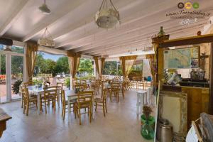 um restaurante com mesas, cadeiras e janelas em Torre Sabea em Gallipoli