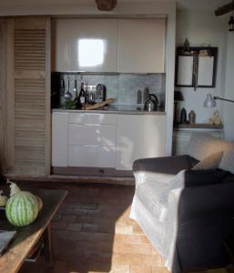 a living room with a couch and a kitchen at la maison aux bonsais in Saint-Paul-de-Vence