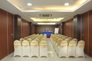 une salle de conférence avec des rangées de chaises et une scène dans l'établissement Horison Express Sentani, à Jayapura